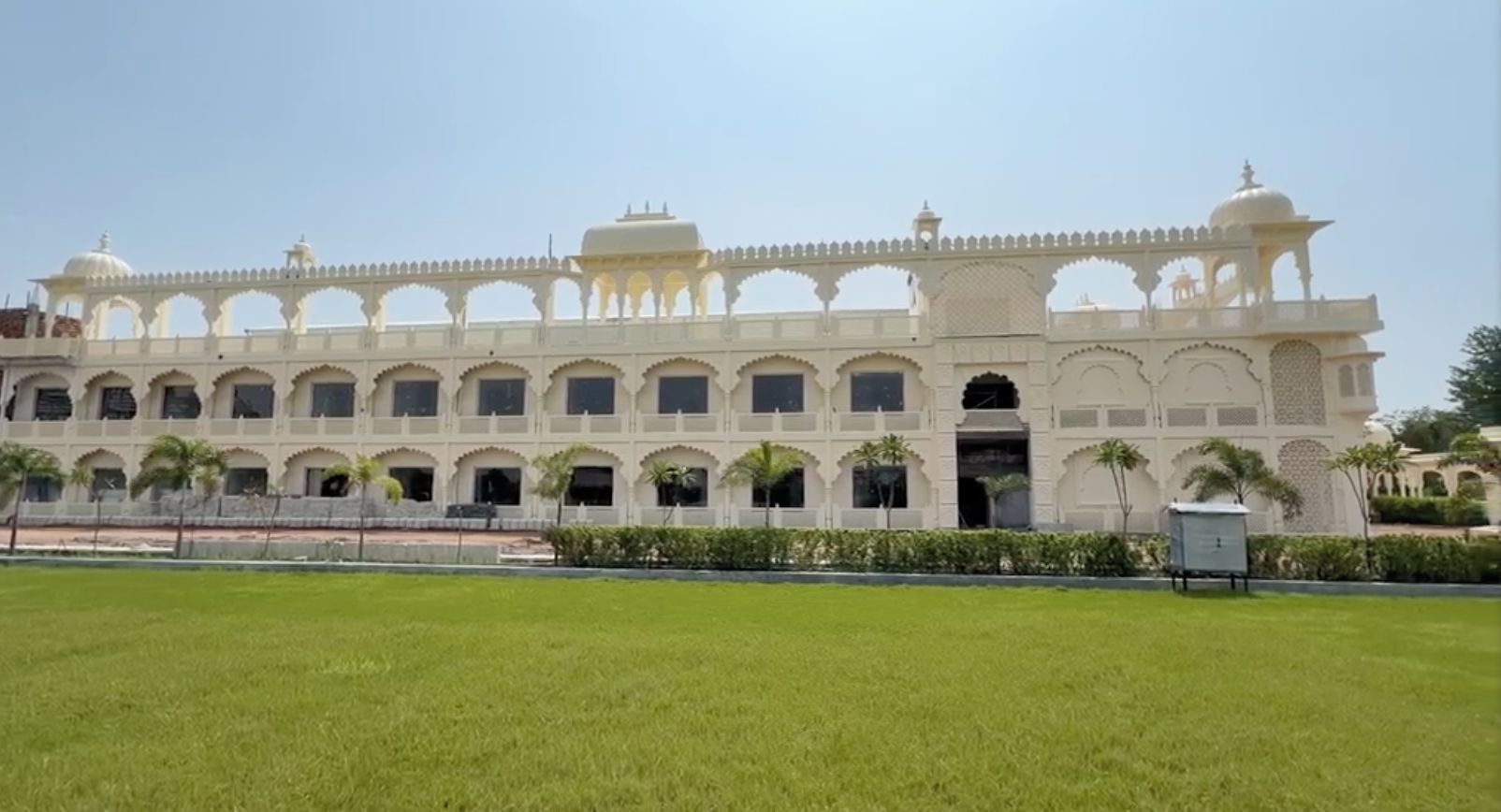 A large, multi-story building with a symmetrical facade, arched windows, and a central entrance.