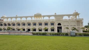 A large, multi-story building with a symmetrical facade, arched windows, and a central entrance.