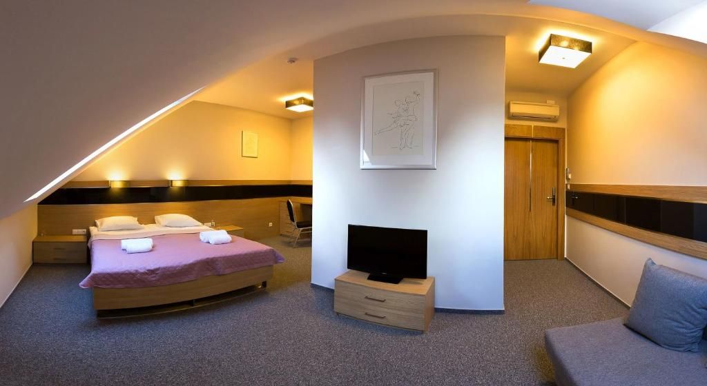 Ein Schlafzimmer mit einem Bett, einem Fernseher, einem Schminktisch und einer Tür.
