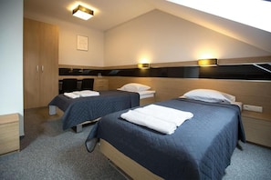 A hotel room with two beds, a desk, and a wardrobe. - Hotel Karo (Zakrzew)