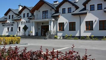 Um hotel com entrada destacada, varanda e uma placa com a inscrição 'KARO'.
