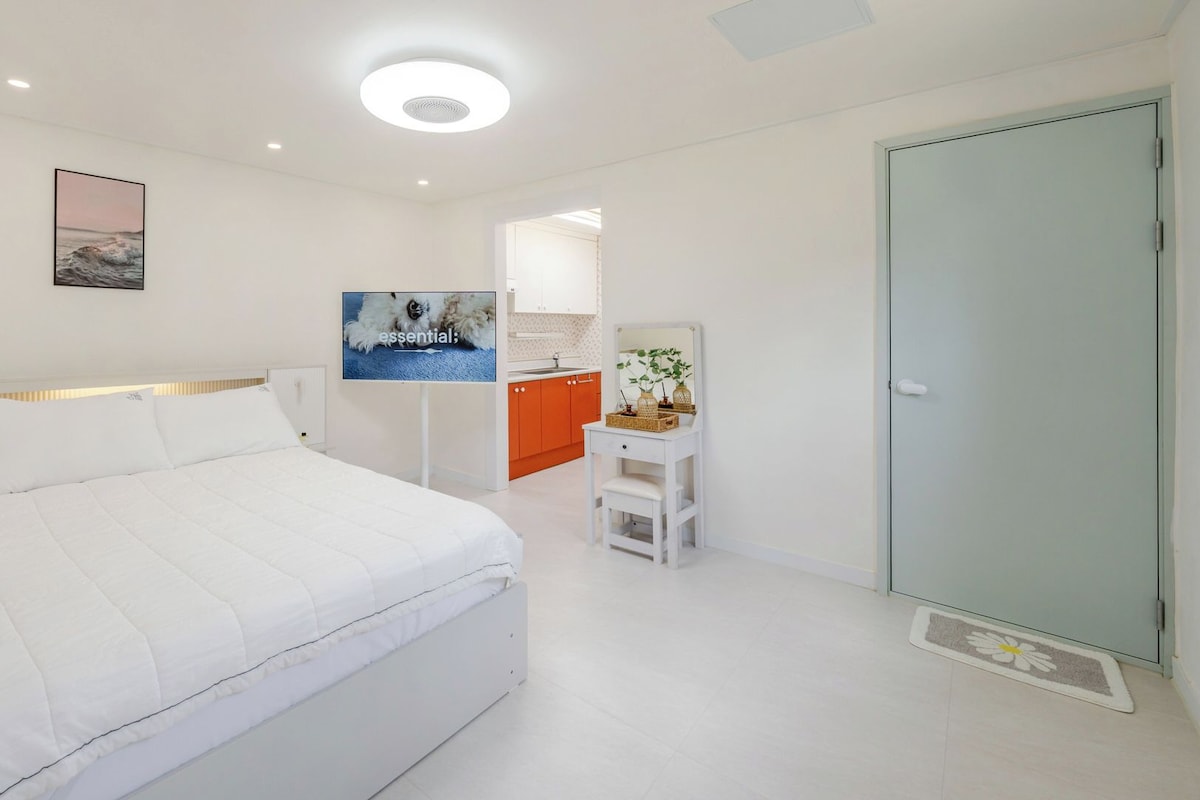 Quarto moderno com cama grande, escrivaninha e guarda-roupa.