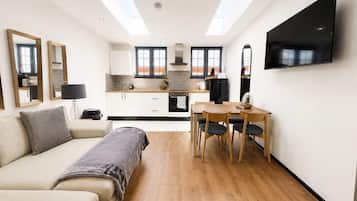 A modern apartment with a living area, kitchenette, and dining space.