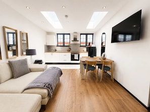 A modern apartment with a living area, kitchenette, and dining space. - Modern 2 Bed Flat in Heart of Warrington City (Warrington)