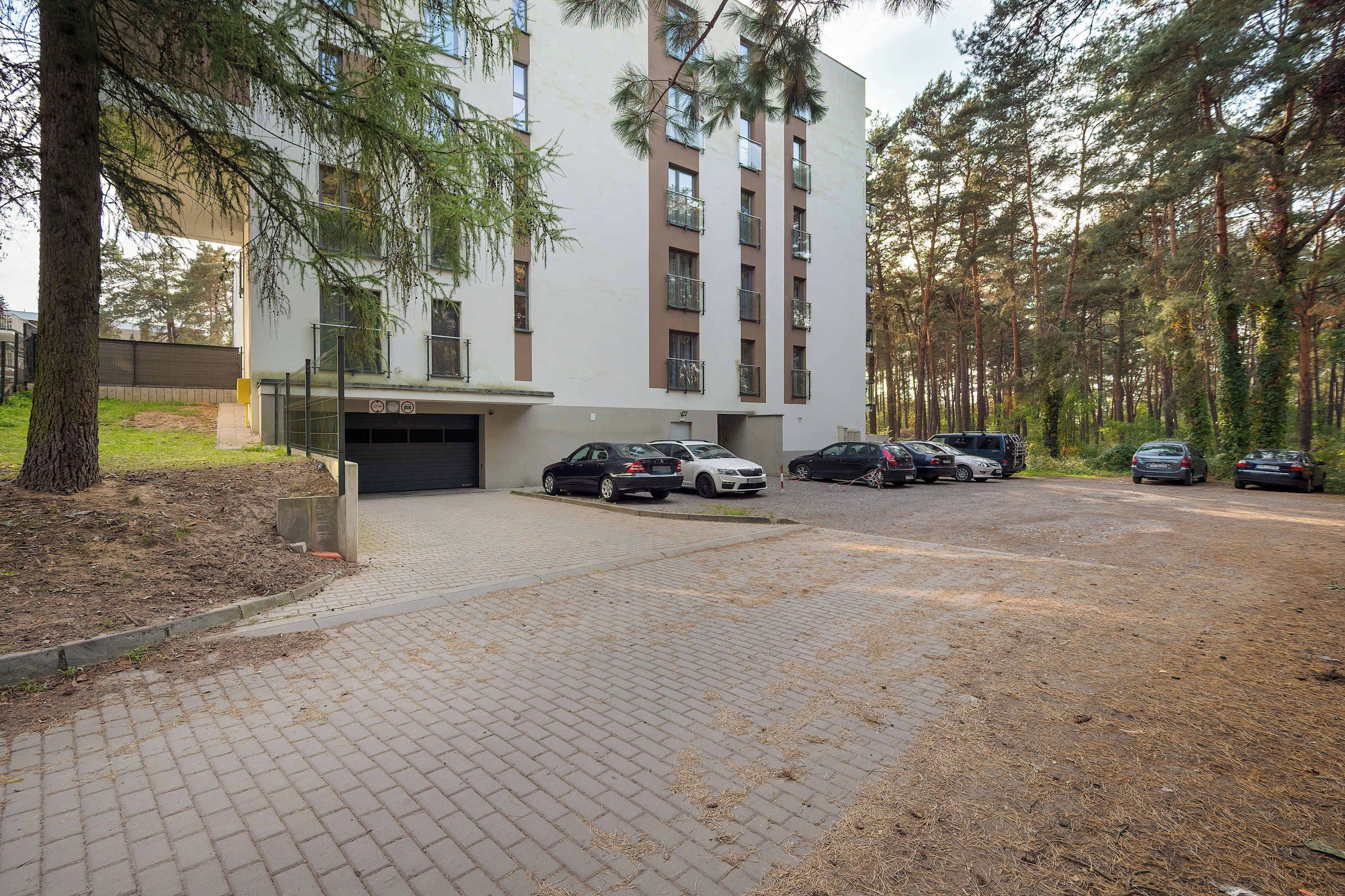 Ein mehrstöckiges Gebäude mit Parkplatz davor.
