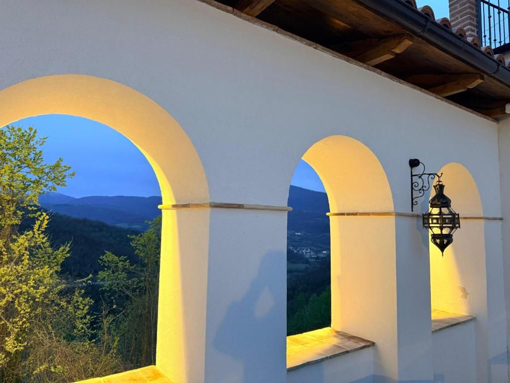 Un edificio blanco con ventanas de arco y un farol.