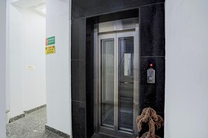 An elevator with a digital display and a no-smoking sign on the wall.
