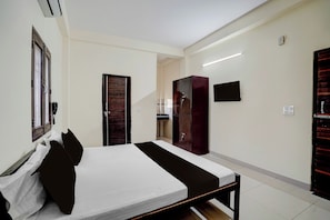 A hotel room with a bed, a wardrobe, a television, and a bathroom visible through an open door. - Hotel O Prime Stay (Noida)