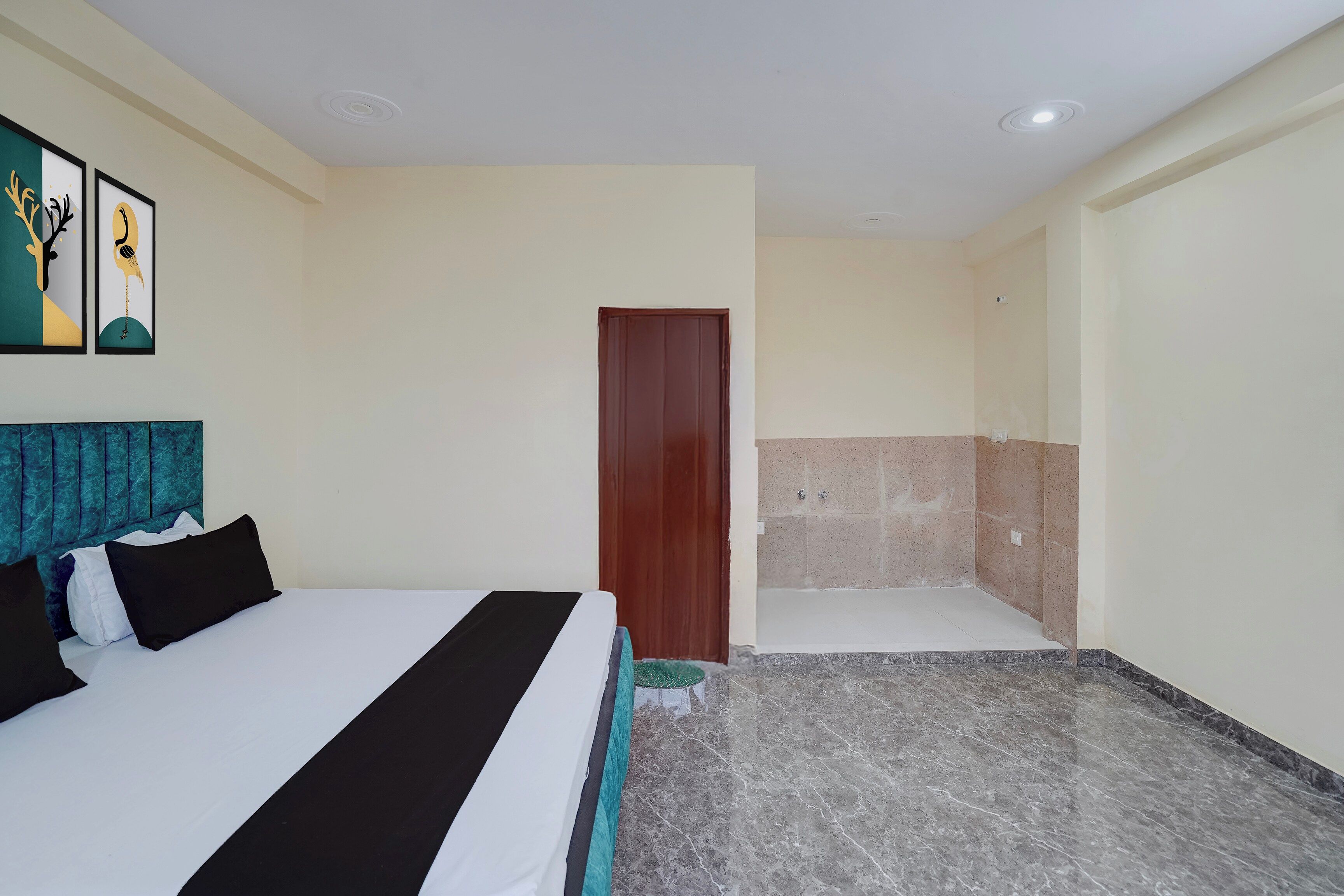 A hotel room with a bed, a shower area, and a door.