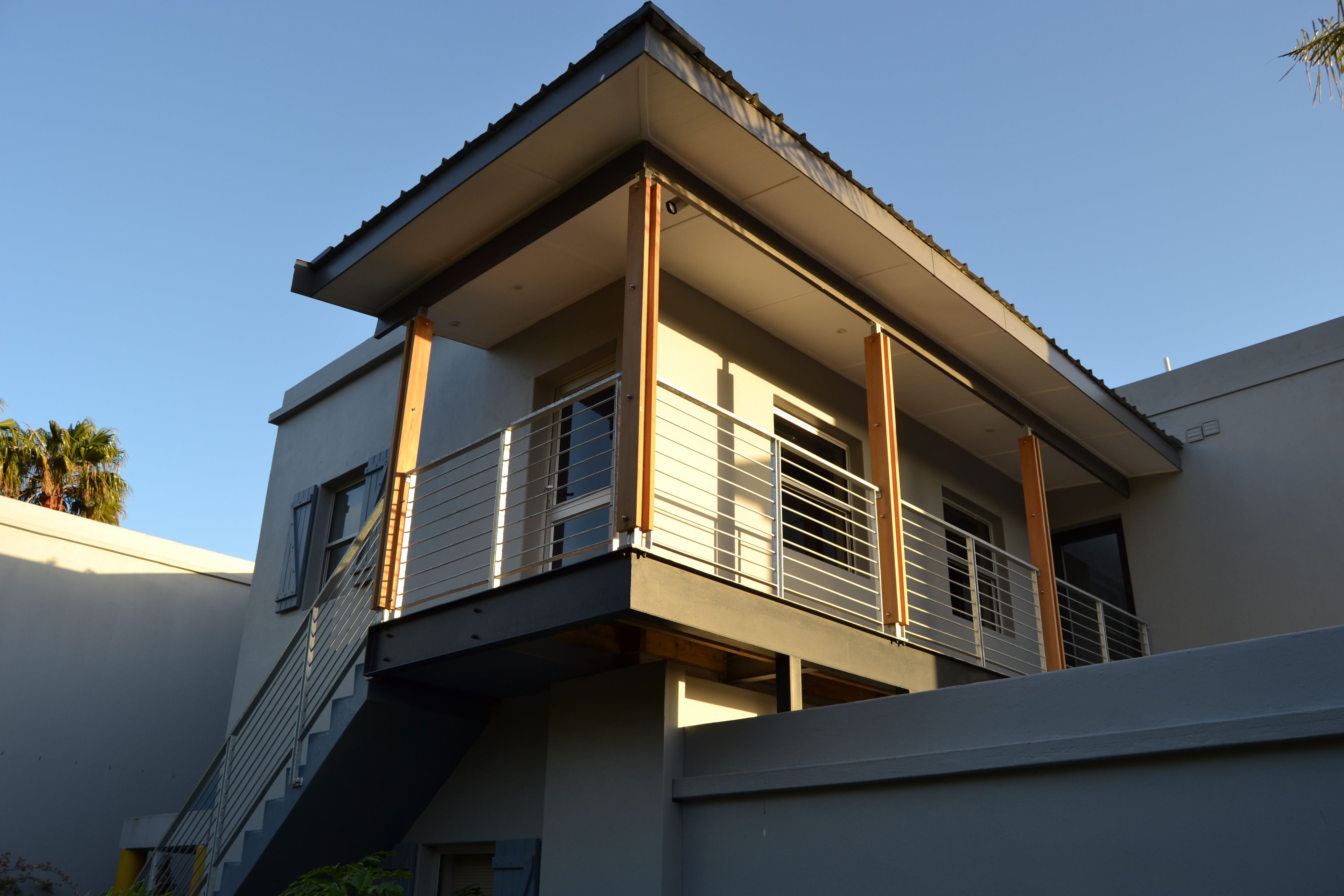 Ein modernes, zweistöckiges Gebäude mit Balkon und Treppe.