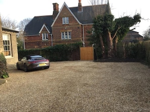 A residential driveway with a car parked in front of a brick house. - The Old Rectory (King's Lynn)