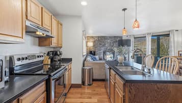 A modern kitchen with wooden cabinets, a stove, and a large island with a sink.