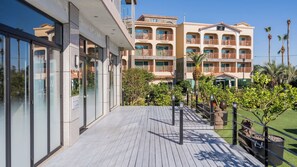 Ein Hotel mit einer Holterrasse, mehreren Balkonen und üppiger Bepflanzung.