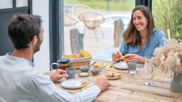 Una mesa de comedor con comida, incluyendo pan, una taza y un frasco de miel.