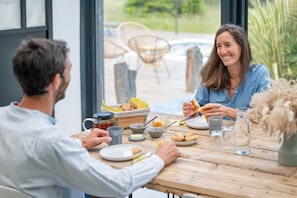 A dining table with a meal, including bread, a cup, and a jar of honey.