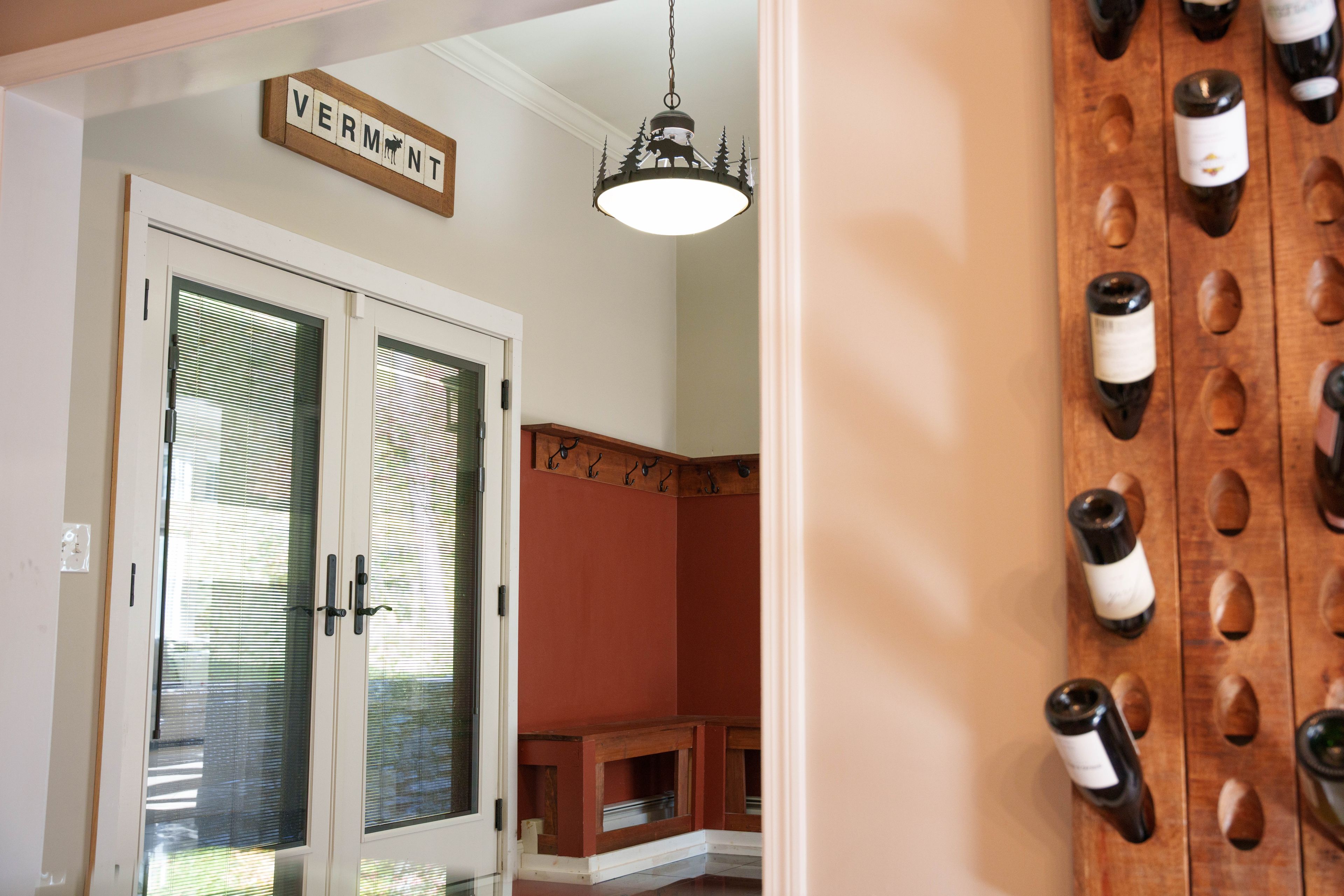 A room with a door labeled 'VERMONT' and a wine rack with bottles.