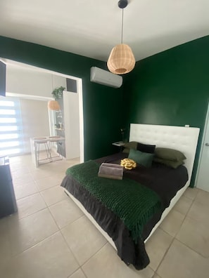 A bedroom with a bed, a nightstand, a hanging lamp, and a window. - Lovely 1 bedroom apartment close to everything SJ (San Juan)