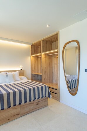 Une chambre à coucher avec un lit, un meuble de rangement en bois et un grand miroir.
