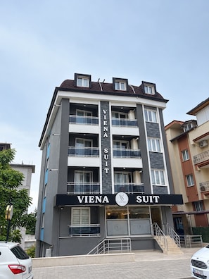 Um edifício de vários andares com uma placa indicando 'VIENA SUIT', sinalizando um hotel ou alojamento.