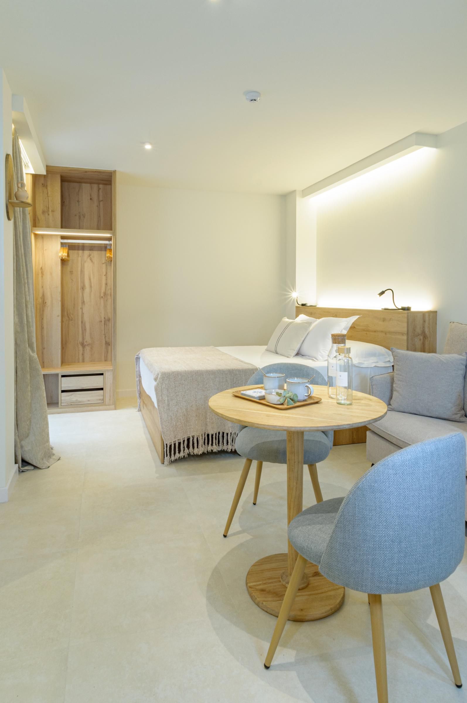 Une chambre à coucher moderne comprenant un lit, une table de chevet, une table ronde avec des chaises et un canapé.