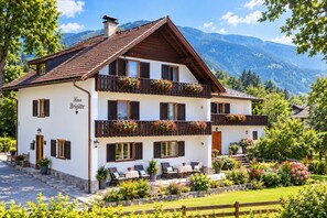 A two-story building with balconies, a sign reading 'Haus Brigitte,' and a garden with various plants. - New Listing (Großdombra)