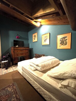 A room with a bed, dresser, and artwork on the wall. - New Listing (Megève)