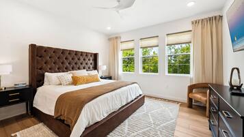 A bedroom with a large bed, bedside tables, a desk, and a chair.