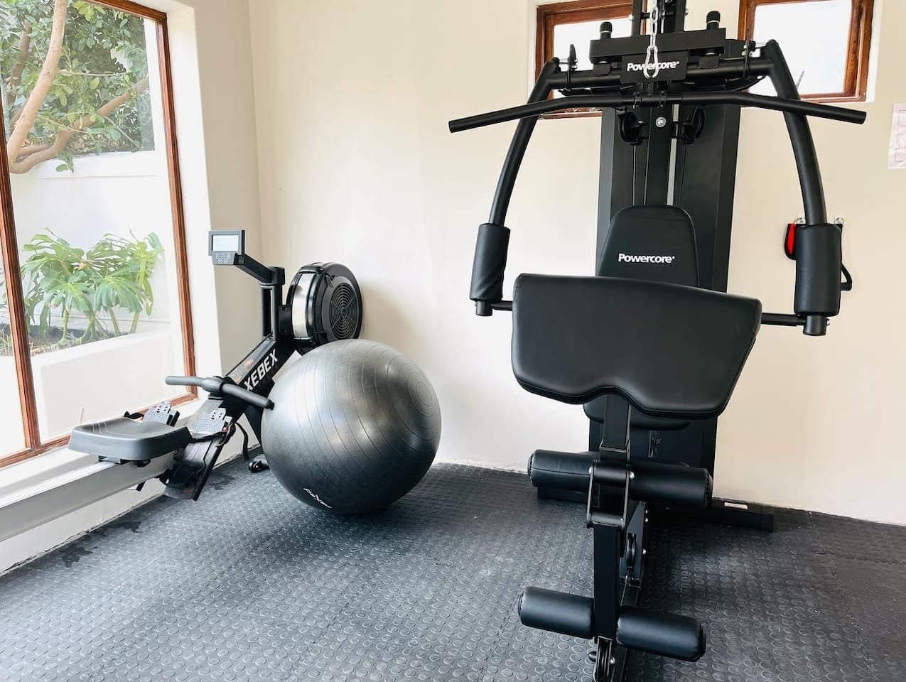 Una palestra con una cyclette, un pallone da medicina e una panca per pesi.