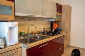 A kitchen with a double sink, a coffee maker, and a stove. - B&B 31mt dal Duomo (Benevento)