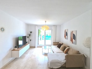 Un saló modern amb televisió plana, un sofà, una taula de centre i una planta decorativa.