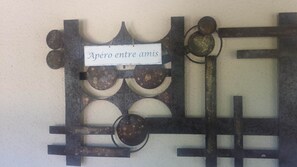 A wall-mounted metal artwork with a sign that reads 'Apéro entre amis'.