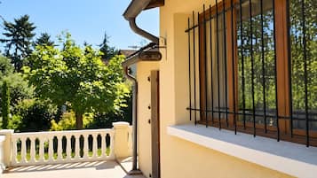 Un bâtiment doté d’un balcon, d’une fenêtre avec des barreaux en métal et d’une rambarde blanche.
