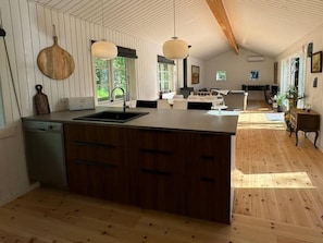A spacious kitchen with wooden cabinets, a central island, and pendant lighting.