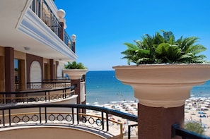 A hotel balcony with a view of the beach and ocean.