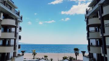 Un balcón de hotel con vista a la playa y al mar.