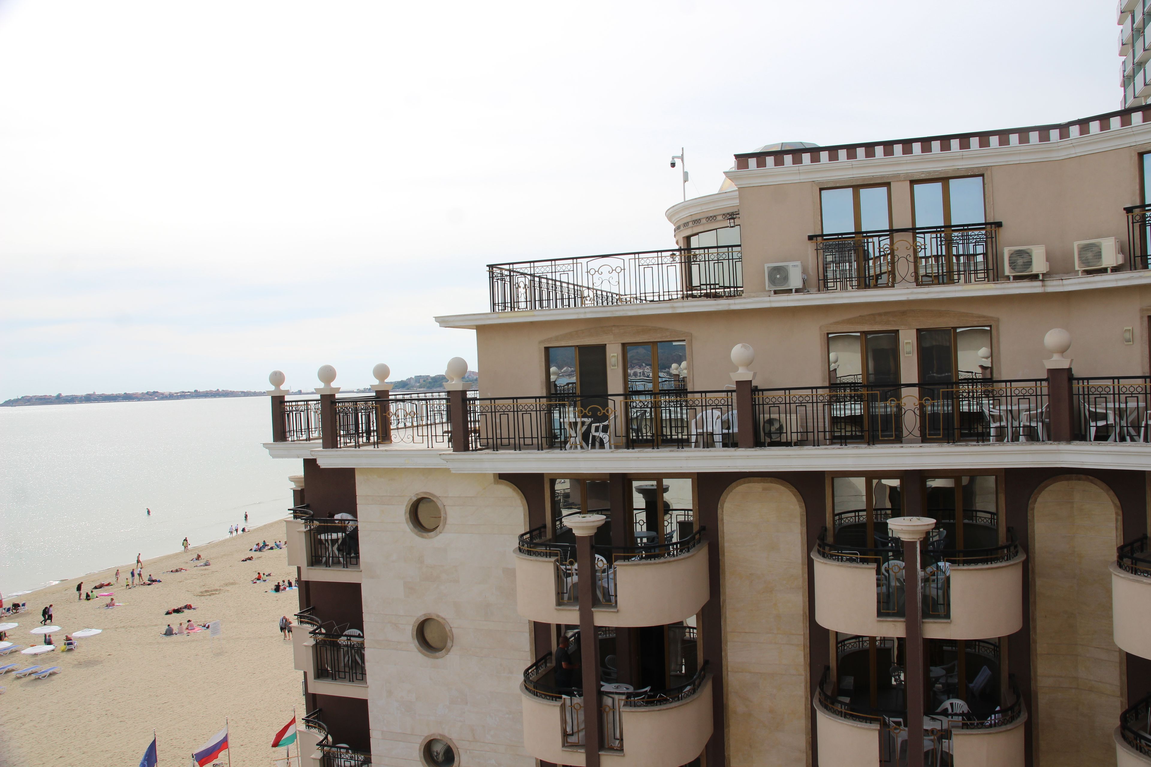 Un hotel de varios pisos con balcones que dan a una playa.