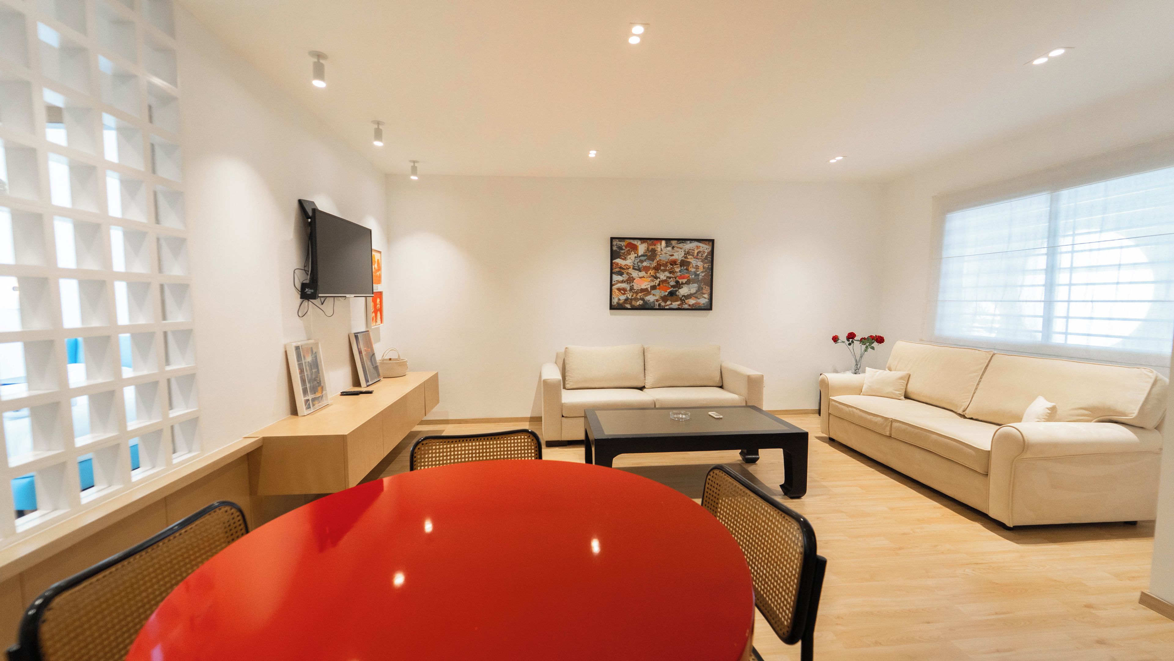 Un salon moderne avec un canapé, une table basse et un téléviseur fixé au mur.