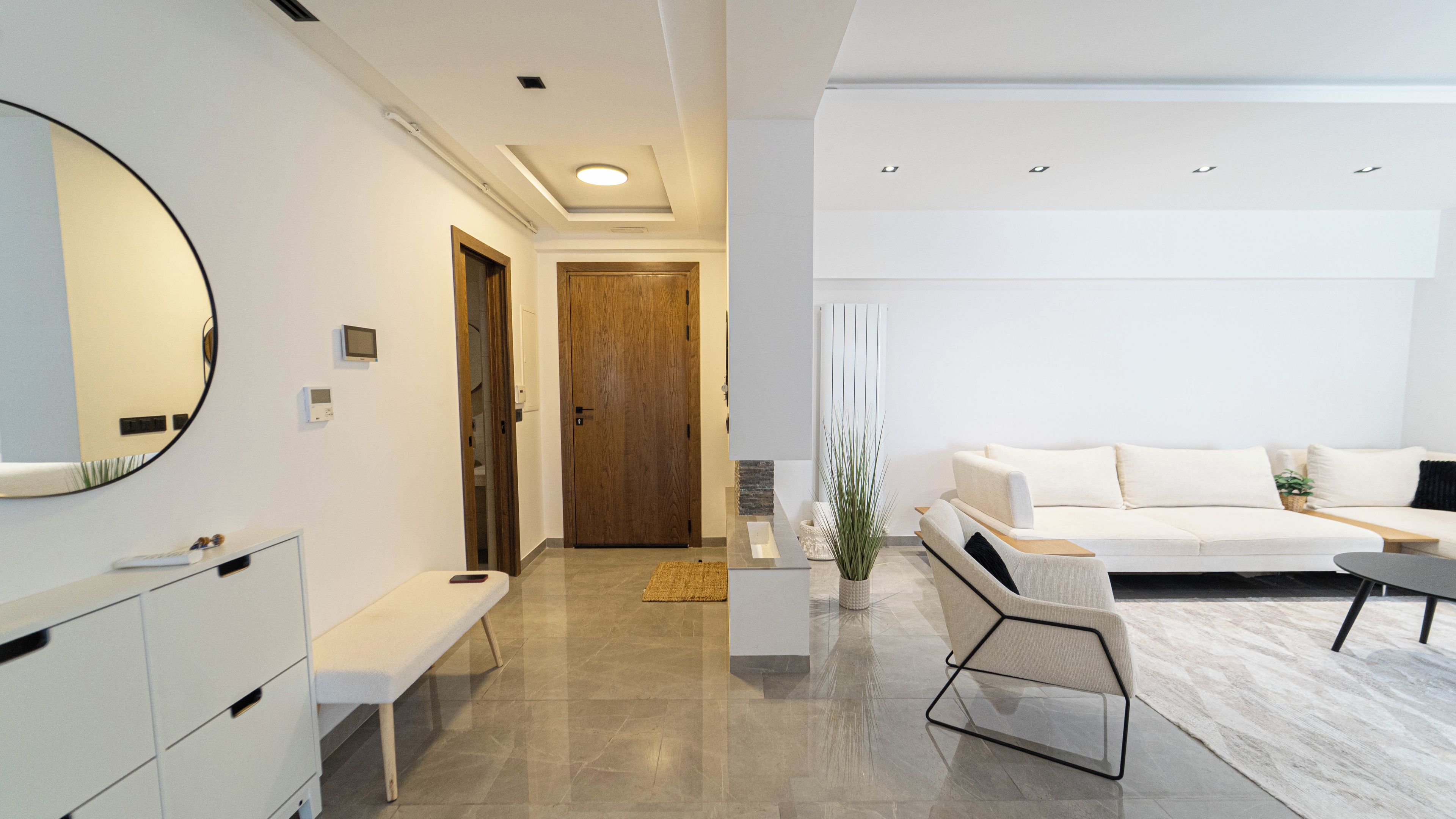 Uma sala de estar moderna com um sofá, uma mesa de centro e um banquinho.