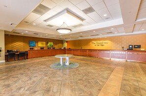 A spacious lobby with a reception desk, a round table, and artwork on the walls. - Cozy 1-bedroom hotel in brilliant Las Vegas with AC and fitness room (Las Vegas)