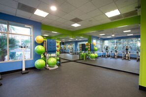 A gym with exercise equipment, large windows, and a mirrored wall. - Cozy 1-bedroom hotel in brilliant Las Vegas with AC and fitness room (Las Vegas)
