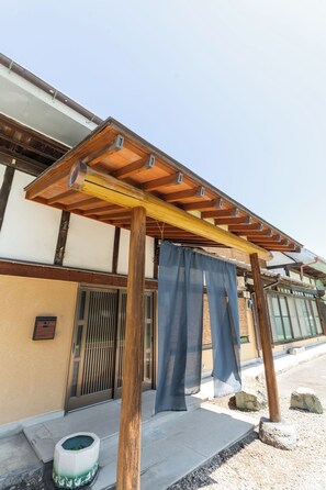 Un edificio japonés tradicional con estructura de madera y un porche cubierto.