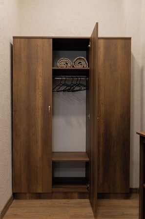 Un armario de madera con espacio para colgar y un estante.