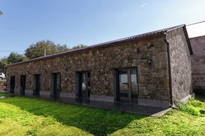 A stone building with a flat roof, multiple doors, and a paved entrance area. - Noosh Dsegh Boutique Hotel (Dsegh)