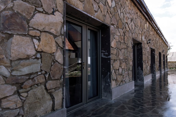 A stone building with large windows and a covered walkway. - Noosh Dsegh Boutique Hotel (Dsegh)