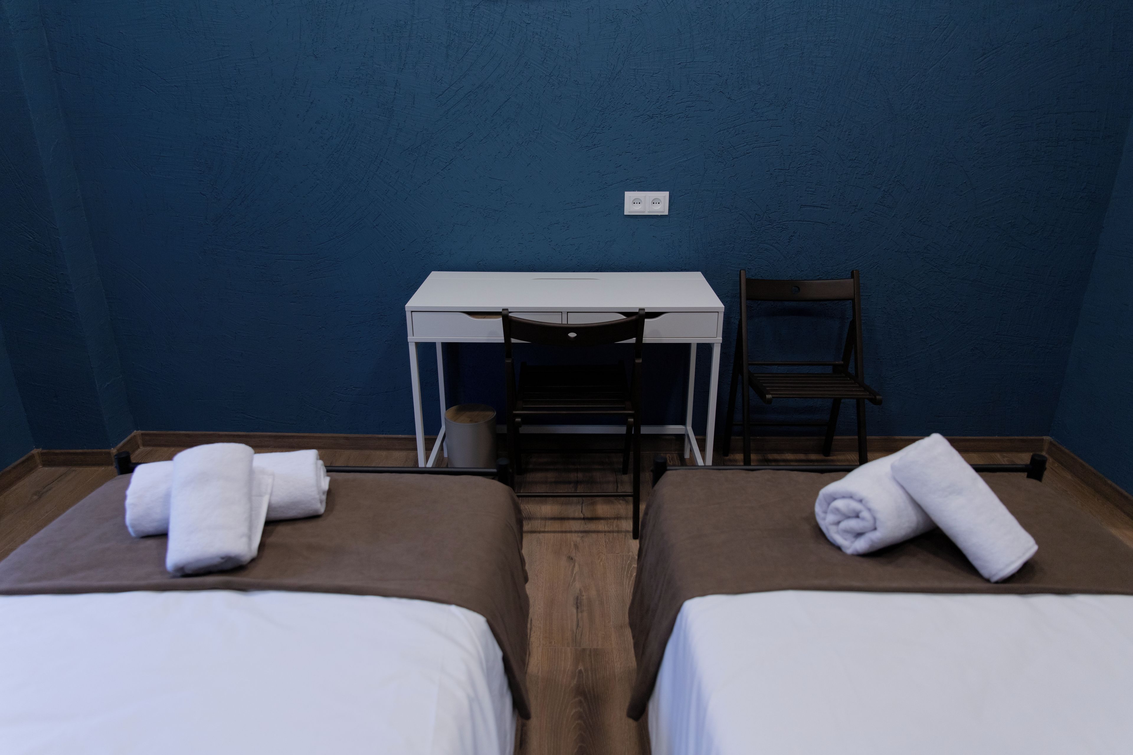 A room with two beds, a desk, and a chair.