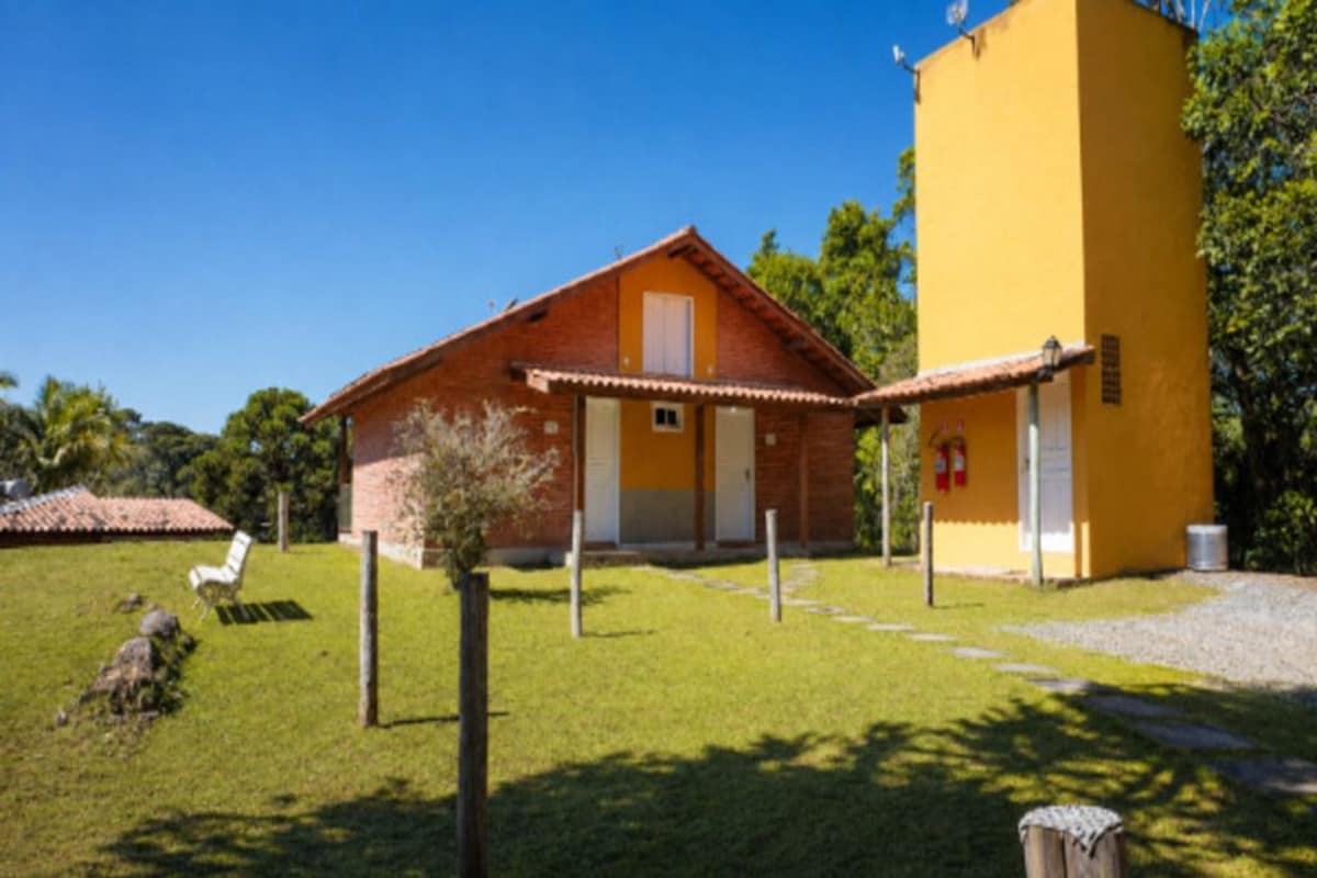 Un edificio de dos pisos con fachada de ladrillo y una torre amarilla.