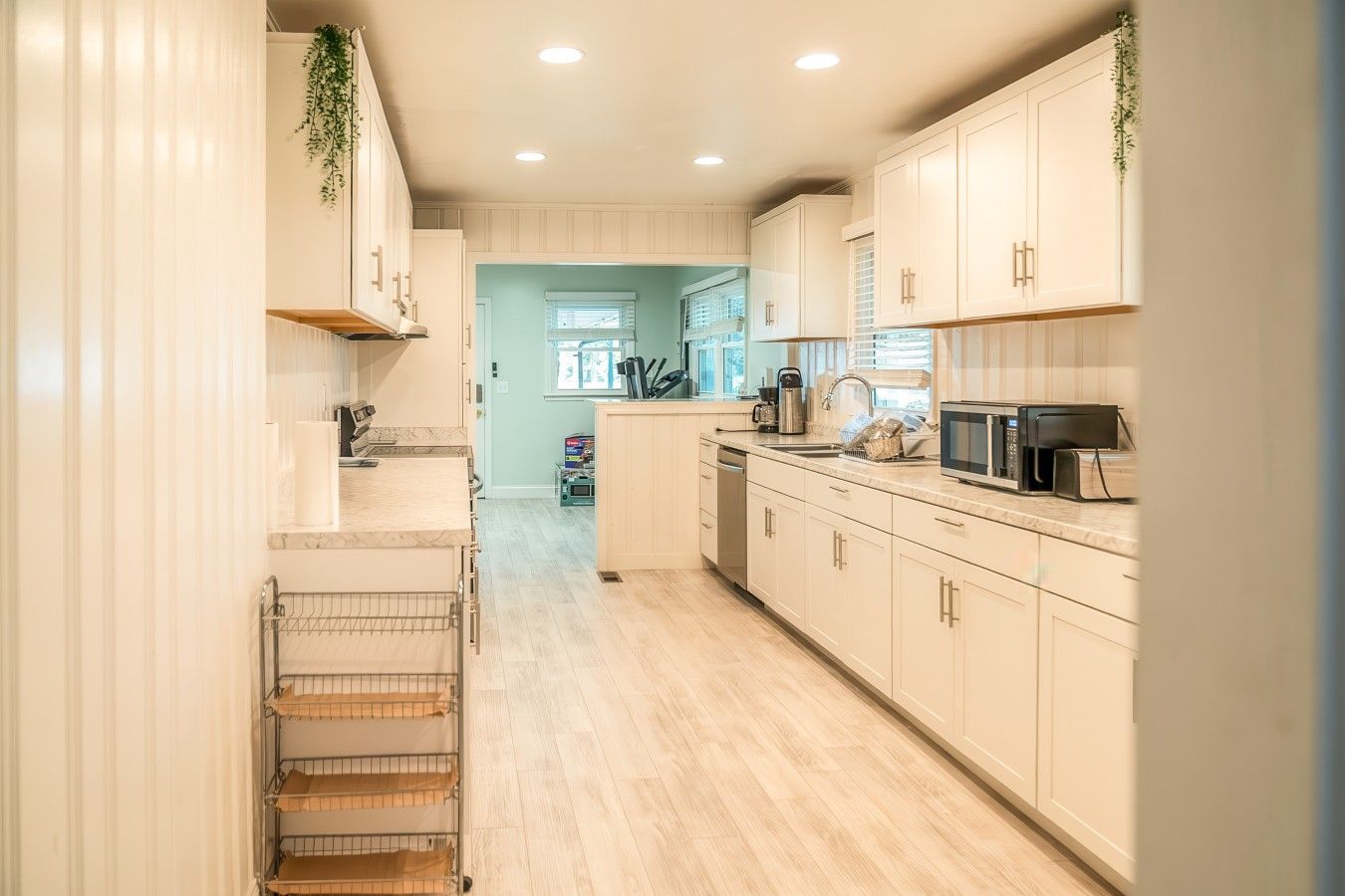 A kitchen with white cabinets, a microwave, and a coffee maker.