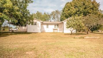 A single-story house with a front yard, a driveway, and a parked car.