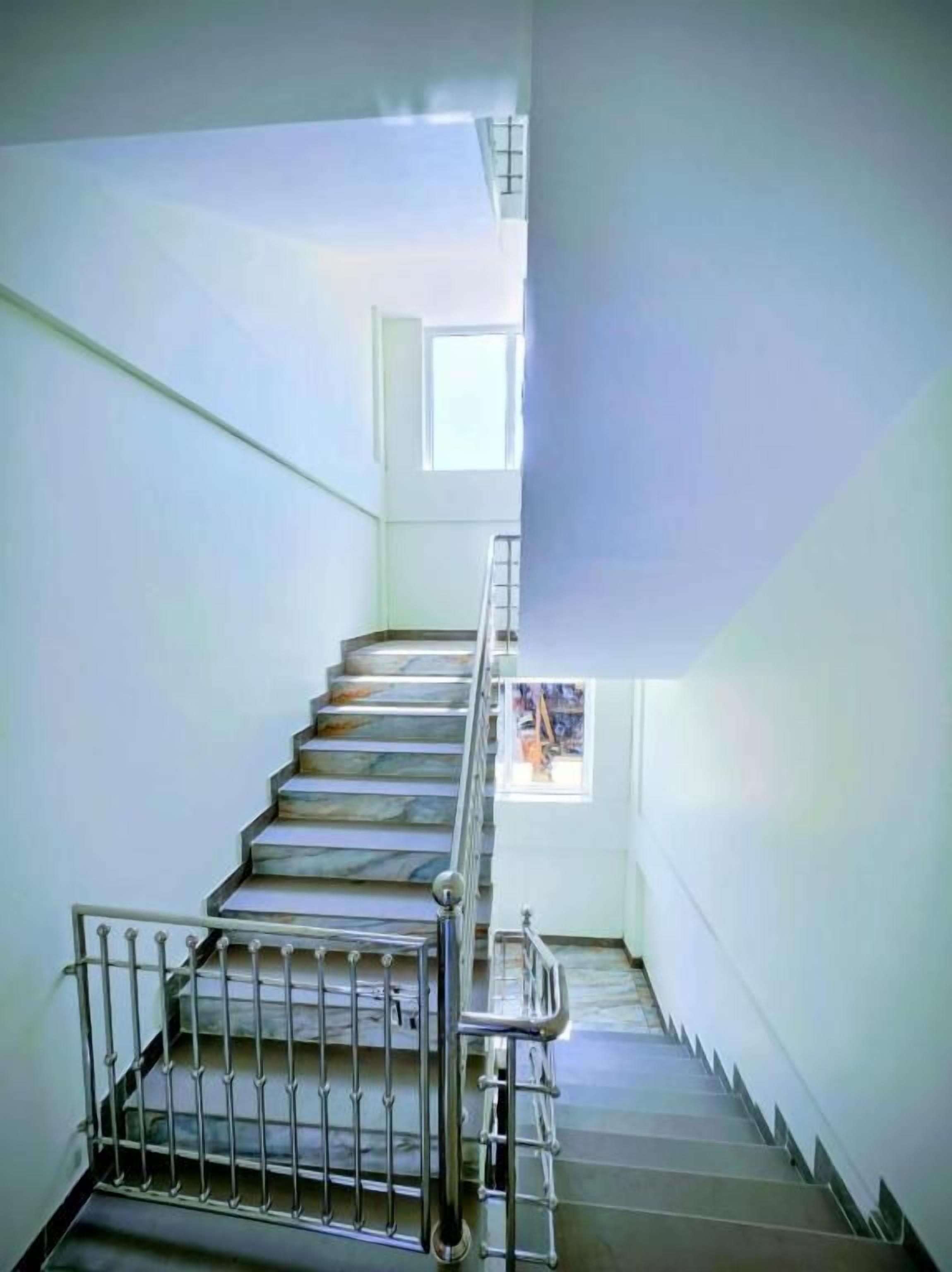 A staircase with metal railings leading to an upper floor.