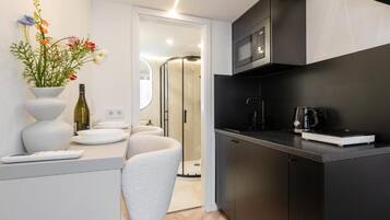 Una cocina moderna con microondas, cafetera y un florero con flores sobre la encimera.